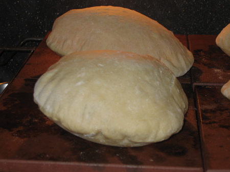 A closeup of the nicer two pita bread in the oven